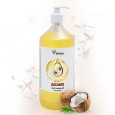 Fles Verana Kokos massageolie met kokosnoten op de achtergrond.