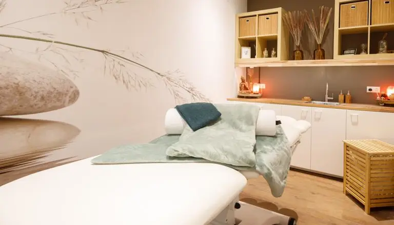 Massagetafel in een rustgevende ruimte met kitchenette, gebruikt voor ontspanningsmassages